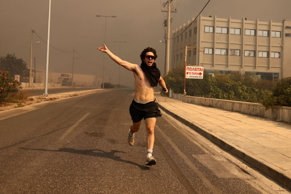 ATHENS, GREECE - AUGUST 12: A man runs, during a wildfire in Nea Penteli near Athens, Greece, on August 12, 2024. (Photo by Costas Baltas/Anadolu via Getty Images)