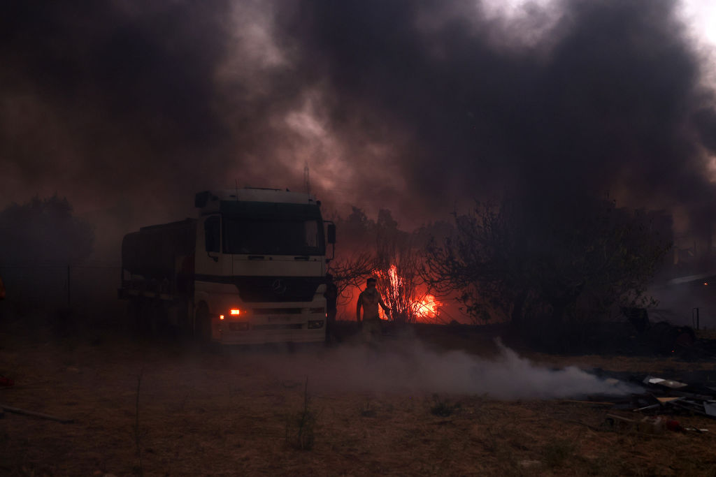 ATHENS, GREECE - AUGUST 12: People try to extinguish a wildfire in Nea Penteli near Athens, Greece, on August 12, 2024. (Photo by Costas Baltas/Anadolu via Getty Images)